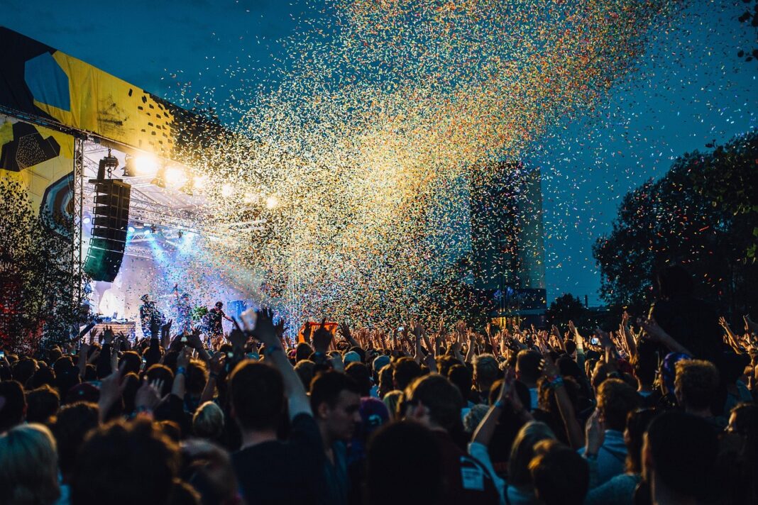 LBV-018 Menschenmenge auf einem Open-Air-Konzert bei Nacht, bunte Konfetti fliegen durch die Luft vor einer hell erleuchteten Bühne.